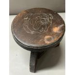 Wooden stool with a carved bulldog print to top