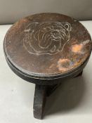 Wooden stool with a carved bulldog print to top