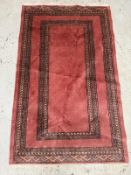 A wool rug with pink grounds and geometric border (160cm x 96cm) Condition Report Some marks
