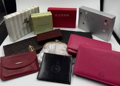 A selection of new leather purses and wallets, some branded