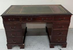 A reproduction desk with leather inlay to top with centre drawer flanked by four drawers either side