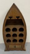A wooden boat-shaped nine-bottle wine rack or bar companion with a single drawer under H92cm W43cm