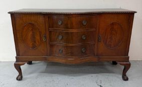 A mahogany serpentine sideboard with three drawers to centre on claw and ball feet H95cm W152c D61cm