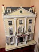 A substantial doll's house by Grosvenor Hall, with two doors opening to nine rooms on three