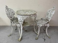 A white cast iron bistro set comprising of a table and two chairs. Height 73cms diameter 62cms