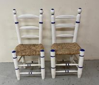 A pair of white painted children chairs with blue accents ad rush seats