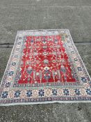 Red ground rug with cream geometric border 280cm x 200cm Condition Report needs cleaning has stains