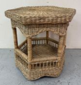 A wicker octagonal side table with shelf under. Height 62cm 67x67 Condition Report Good