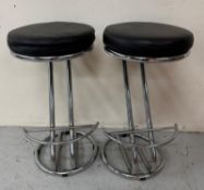 A pair of chrome bar stools with black faux leather seats H70cm