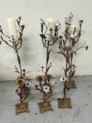 Four floor-standing and two table top candle holders with scrolling metal work, flowers H80cm