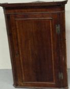 Oak corner cabinet with single door to front and three shelves to inside (H110cm W77cm D40cm