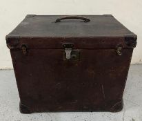 A brown leather trunk or travel case with a leather handle to top and brown leather fixings to