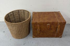 A tan leather storage trunk together with a wicker wash basket