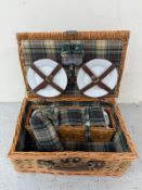 A wicker picnic hamper and set with plates, cups etc