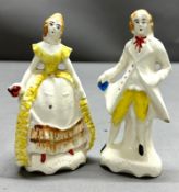 A pair of hand painted porcelain figures of a gentleman and lady in period dress