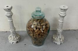A pair of white candlesticks along with lidded glass vases
