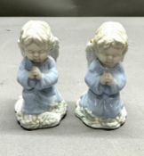 A pair of porcelain cherub candlestick holders