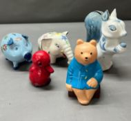 Five money boxes of various forms, including pigs, a duck and a bear