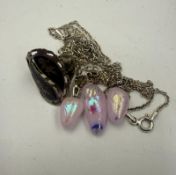 A silver necklace with decorative pink stones, together with a Thai style ring