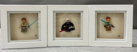 A set of three framed Star Wars Lego figures to include Darth Vadar and Lusk Skywalker