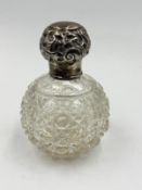 A cut glass silver topped scent bottle with indistinct hallmarks.