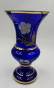 A cobalt blue vase with gilt and floral detail