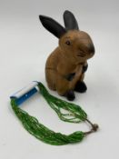 A decorative wooden rabbit and a green costume jewellery necklace