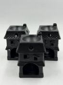 Three ceramic, in black in the style of houses, tea light diffusers.