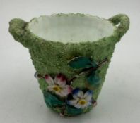A small decorative plant pot with floral relief