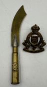 A Trench Art letter opener along with an Army Ordnance Cap Badge.