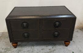 A leather studded chest with four drawers and lion head pulls