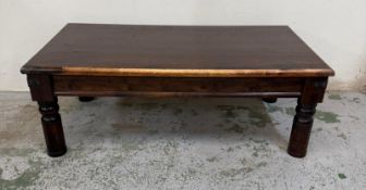An Indian hardwood coffee table with brass fixings on turned legs H40cm W112cm D60cm