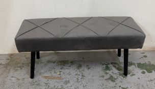 A contemporary grey upholstered bench seat