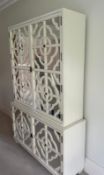 Tall cabinet featuring fretware overlaying mirrored doors, opening to bleached oak adjustable