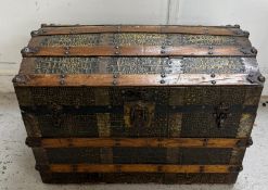 A dome topped brass and wooden banded trunk with crocodile effect top