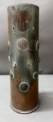 A brass trench art shell case embossed with military buttons