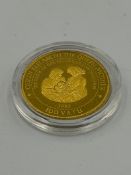 A gold coin celebrating the Queen Mother and Her Great Grandson William's birth Vanuatu 1997 100
