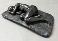 Bronze effect sculpture of a reclining nude female figure