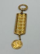 An Arabian three colour gold key ring with an embossed S pendant.