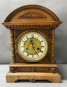 An oak cased German 14-day mantel clock with brass and enamel face, Roman numeral and carved