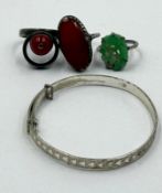 Three vintage silver rings in varying styles and finishes including one jade. Along with a silver