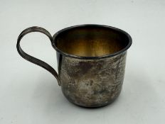 A silver christening cup or baby beaker with indistinct markings on the base