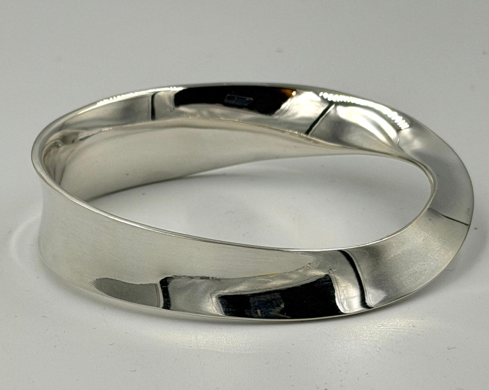 A Georg Jensen silver bangle, with twisted design approximate weight 53g and approximate width 76mm