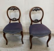 A pair of mahogany balloon-back chairs with purple seats
