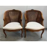 A pair of Louis style wicker open arm chairs on cabriole legs. One AF Height 84cm x 61 width, seat