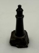 A small marble lighthouse on stone plinth