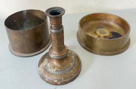 Two World War artillery casings with a trench art candle stic