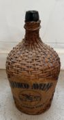 A green glass Carafe in a wicker jacket