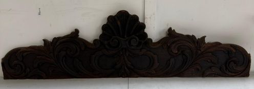 A Dark oak carved pediment with central scallop shell and scrolling relief 108cm wide