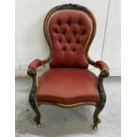 A mahogany button backed nursing chair on cabriole legs and with castors.